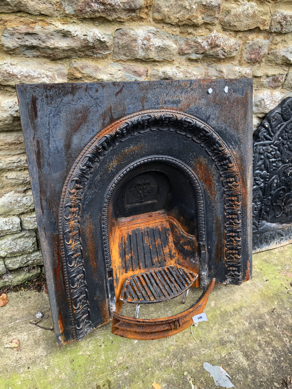 A CAST IRON FIRE SURROUND AND A GRATE.