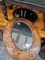 AN ANTIQUE PENWORK FRAMED OVAL MIRROR AND ONE OTHER