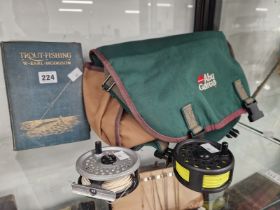 A FISHING BAG CONTAINING ACCESSORIES, TWO FLY FISHING REELS AND A BOOK: TROUT FISHING BY EARL