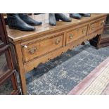 A 19th C. OAK DRESSER BASE WITH THREE MAHOGANY BANDED DRAWERS OVER A CUT WORK APRON AND SQUARE LEGS.