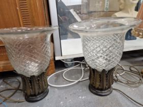 A PAIR OF TABLE LAMPS WITH SINGLE SOCKETS WITHIN GILT METAL LEAVES AND SUPPORTING CUT GLASS BELL