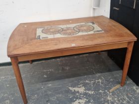 A MID CENTURY TEAK AND TILE TOP EXTENDING DINING TABLE.