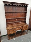 A 19th C. OAK DRESSER WITH AN ENCLOSED THREE SHELF BACK AND A FIVE DRAWER BASE ON BALUSTER TURNED