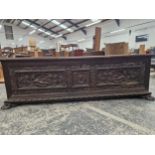 A LARGE WALNUT CARVED FRONT CASSONNE /COFFER . WITH CARVED PAW FEET.