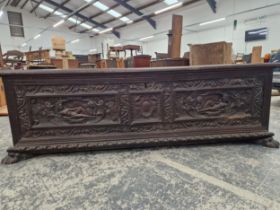 A LARGE WALNUT CARVED FRONT CASSONNE /COFFER . WITH CARVED PAW FEET.