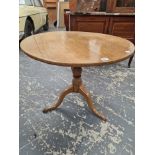 AN ANTIQUE OAK CIRCULAR TILT TOP TABLE ON A BALUSTER COLUMN AND TRIPOD