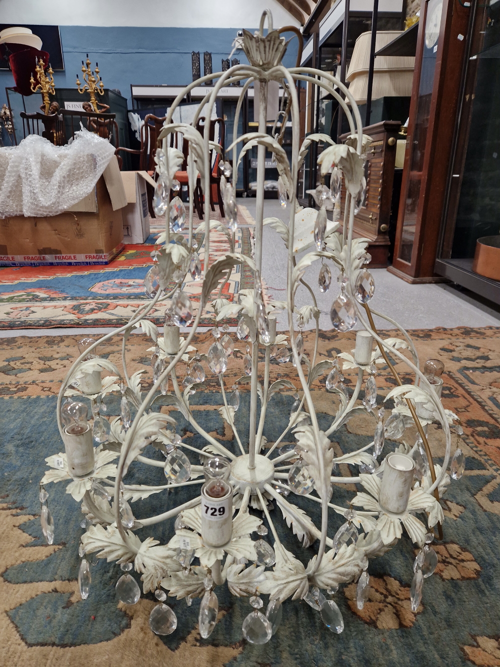 AN EIGHT LIGHT CHANDELIER, THE CREAM PAINTED FOLIATE WIRE WORK HUNG WITH PEAR SHAPED GLASS DROPS.