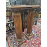 A PAIR OF MOTTLED RED MARBLE TOPPED MAHOGANY FLUTED CYLINDRICAL COLUMNS ON SQUARE FEET. H 115cms.