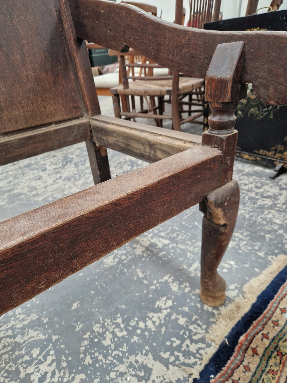 AN 18th C. OAK SETTLE WITH A FIVE PANEL BACK FLANKED BY ARMS ABOVE CABRIOLE FRONT LEGS ON PAD FEET - Image 4 of 7