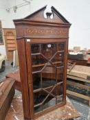 AN ANTIQUE MAHOGANY CORNER CUPBOARD WITH A FOLIATE SCROLL BAND INLAID ABOVE THE GLAZED DOOR
