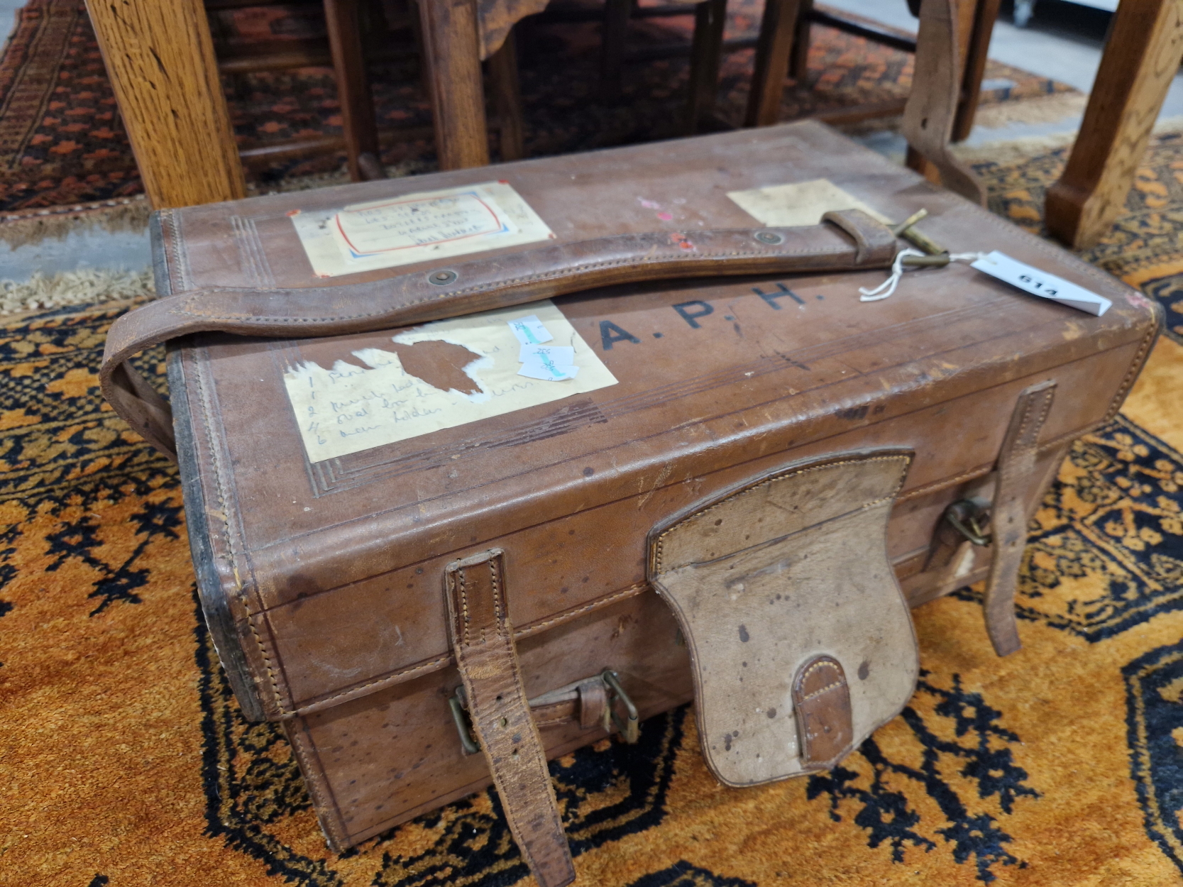 A LEATHER SUITCASE LINED WITH PURPLE BAIZE AND SECURED BY THREE LEATHER STRAPS, THE LID. 51 x