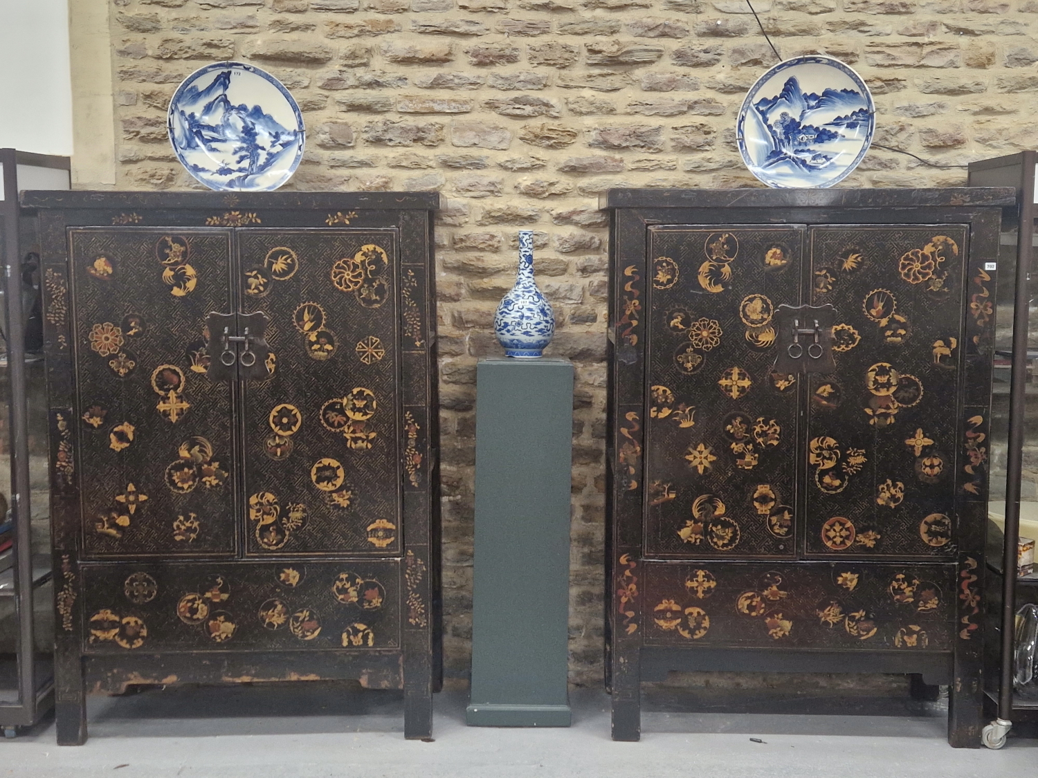A PAIR OF CHINESE BLACK LACQUERED CABINETS, THE DOORS GILT WITH ROUNDELS ON A GEOMETRIC GROUND AND