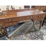 A LATE VICTORIAN MAHOGANY DRESSING TABLE WITH A LOW GALLERIED BACK ABOVE FOUR DRAWERS AND TURNED