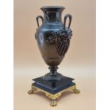 A BRONZE BALUSTER VASE, THE TWO HANDLES WITH BEARDED MASK TERMINALS, THE FOOT RESTING ON BLACK
