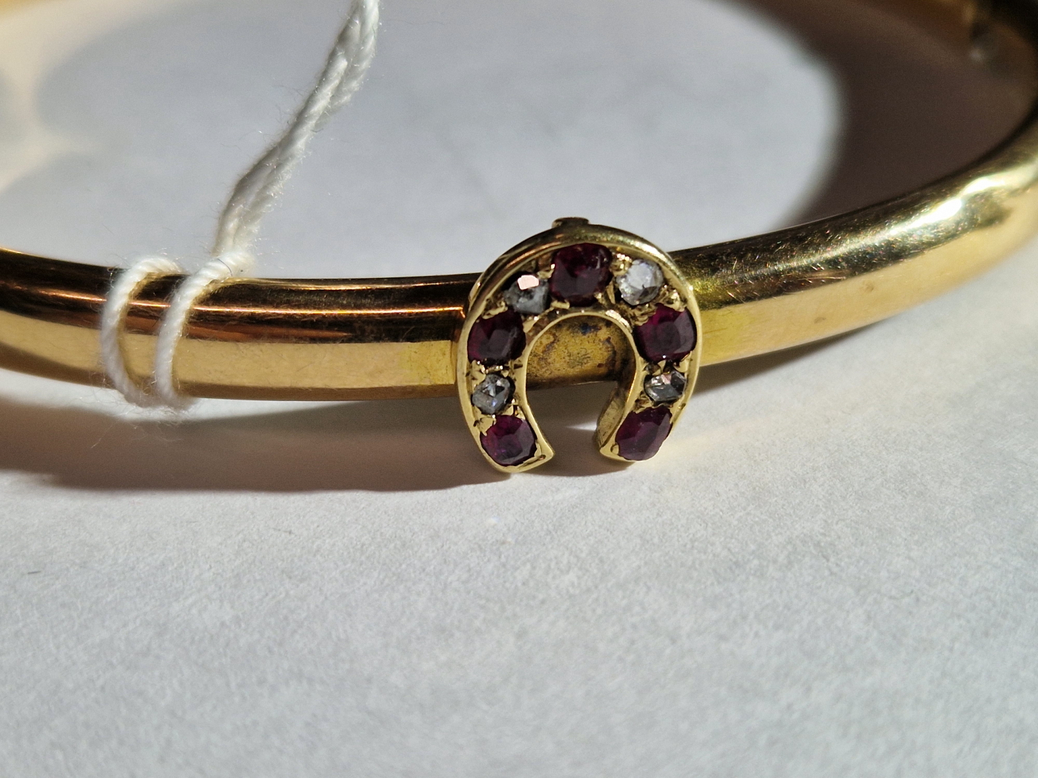 AN ANTIQUE BANGLE SET WITH A RUBY AND DIAMOND HORSESHOE. THE HINGED BANGLE UNHALLMARKED, ASSESSED AS - Image 8 of 8