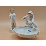 A VICTORIAN ROYAL WORCESTER FIGURE OF A BOY SEATED ON A BRANCH OVERLOOKING A GILT EDGED BASKET. W