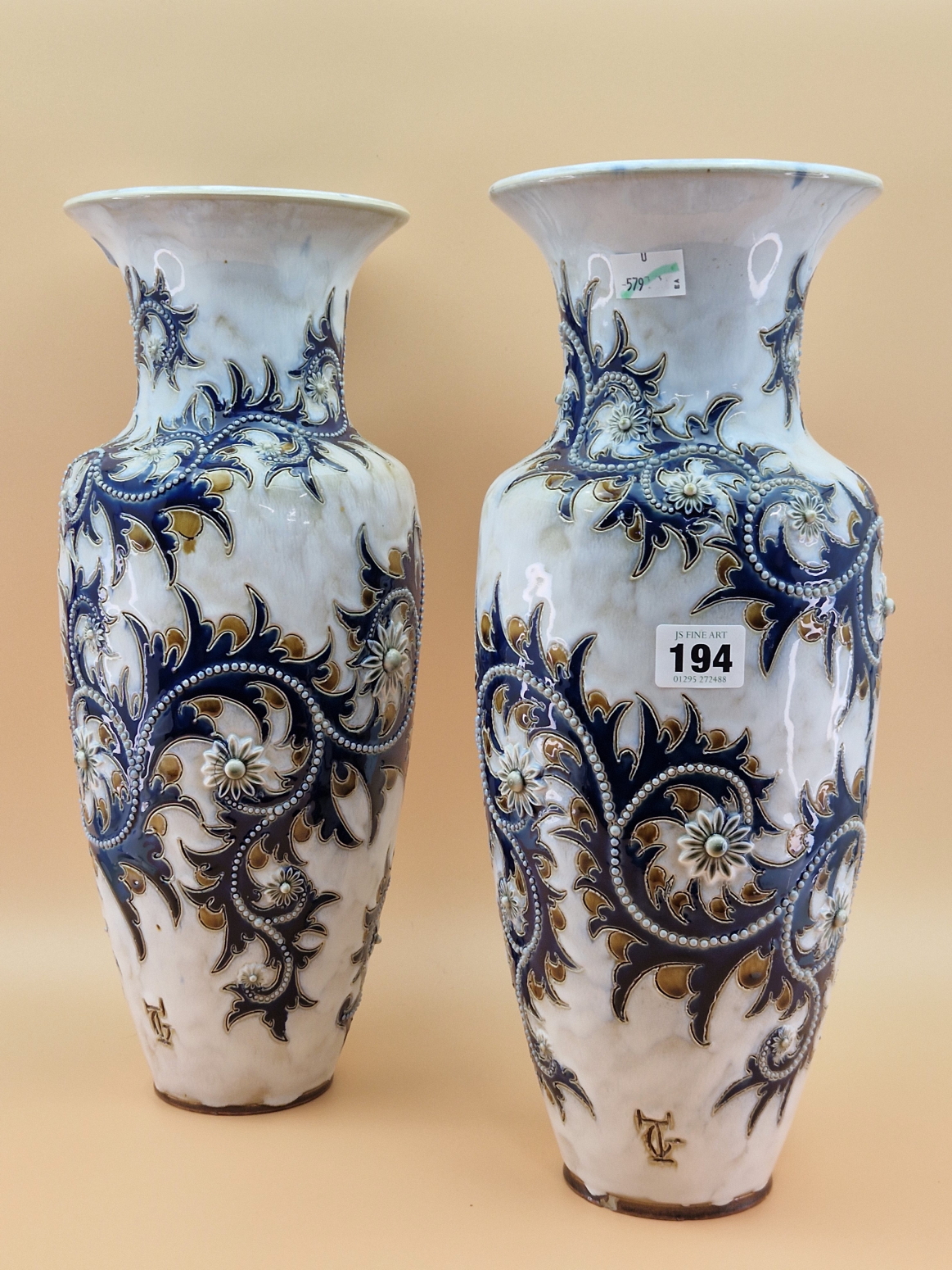A PAIR OF ROYAL DOULTON VASES BY GEORGE TINWORTH DECORATED IN RELIEF WITH BEADED BLUE VINES