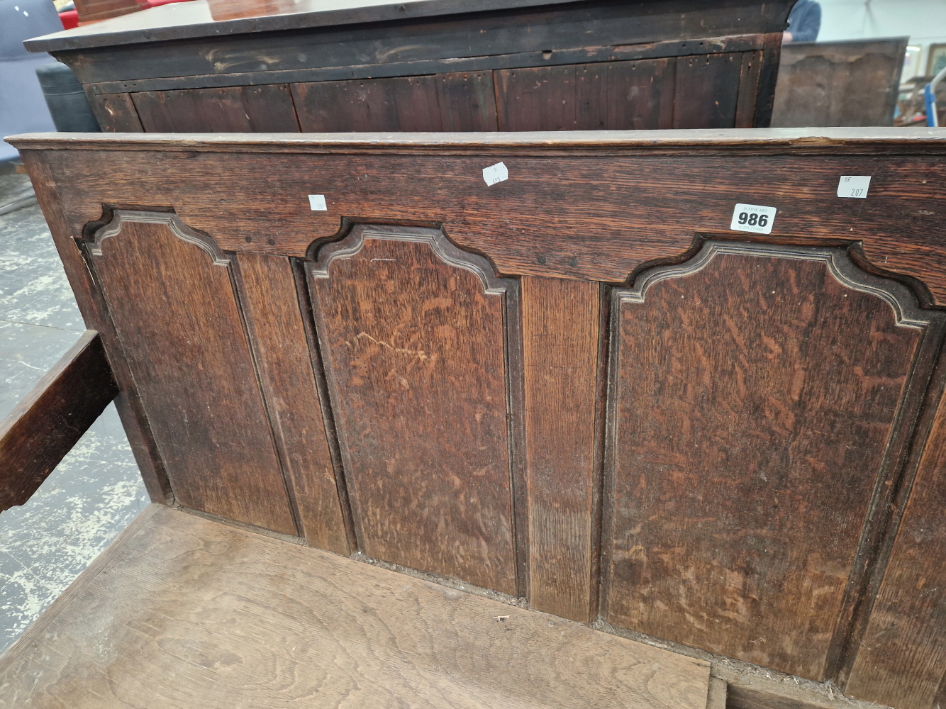 AN 18th C. OAK SETTLE WITH A FIVE PANEL BACK FLANKED BY ARMS ABOVE CABRIOLE FRONT LEGS ON PAD FEET - Image 7 of 7