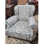 A CONTEMPORARY WING ARMCHAIR UPHOLSTERED IN BLUE DAMASK AND SUPPORTED ON MAHOGANY FRONT BUN FEET