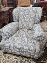 A CONTEMPORARY WING ARMCHAIR UPHOLSTERED IN BLUE DAMASK AND SUPPORTED ON MAHOGANY FRONT BUN FEET