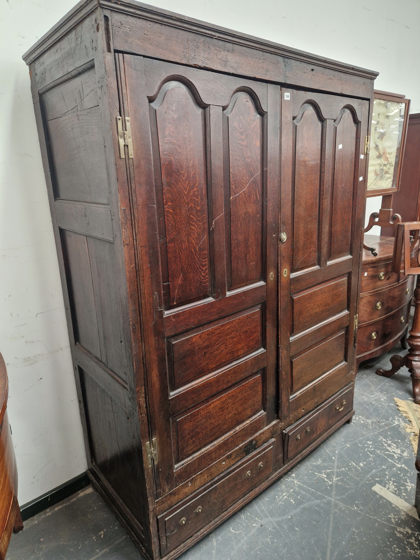 A 18th C. OAK CUPBOARD WITH PANELLED DOORS ENCLOSING HANGING SPACE OVER TWO SHORT DRAWERS. W 141 x D