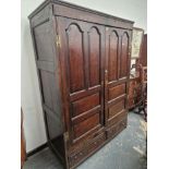 A 18th C. OAK CUPBOARD WITH PANELLED DOORS ENCLOSING HANGING SPACE OVER TWO SHORT DRAWERS. W 141 x D