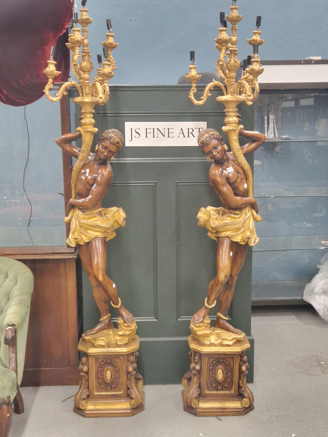 A PAIR OF PARCEL GILT WOOD SEVEN LIGHT CANDELABRA HELD UP BY NUBIAN FIGURES STANDING ON SQUARE