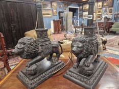 A PAIR OF BRONZE LION TABLE LAMPS, EACH STANDING WITH A FOREPAW RAISED ON A BROCADE BALL, THE