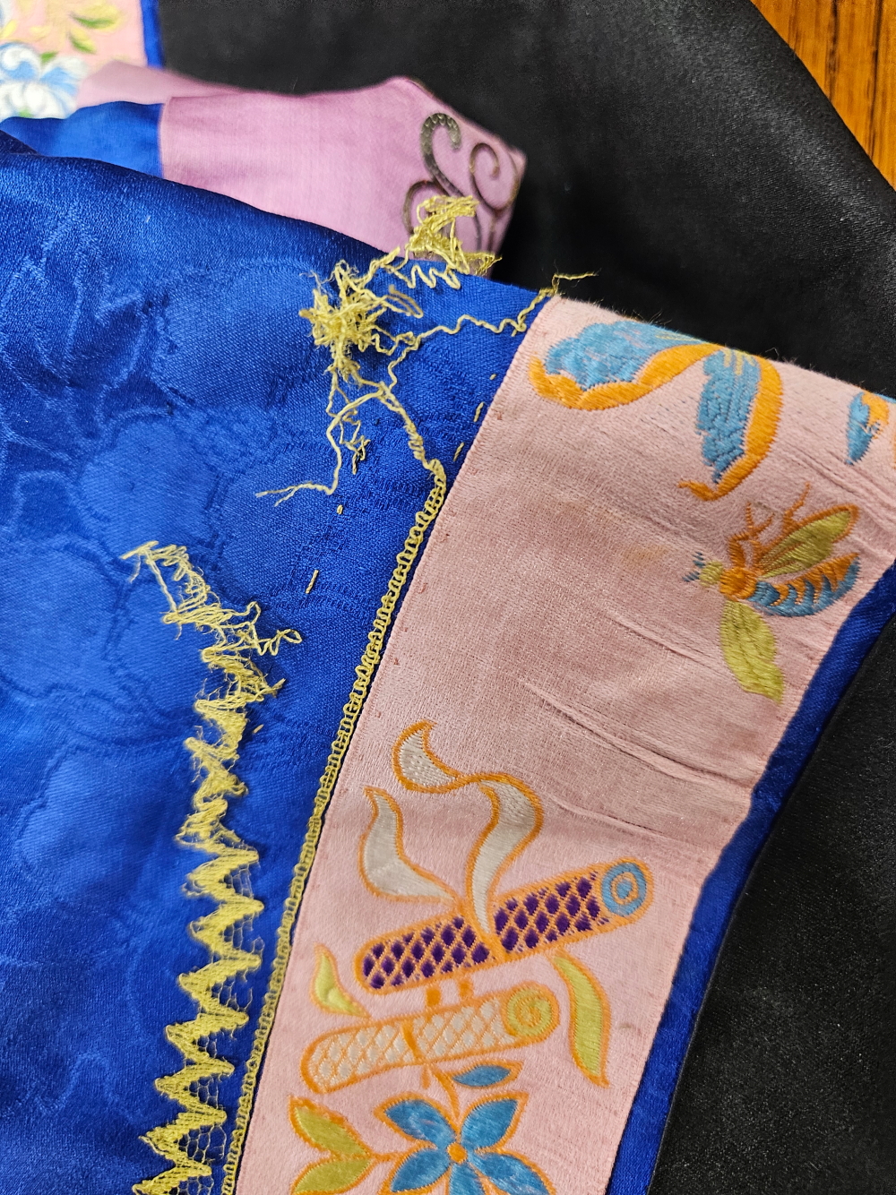 A CHINESE QUILTED DEEP BLUE AND BLACK SILK JACKET EDGED WITH A PINK GROUND FLORAL BAND - Image 26 of 27