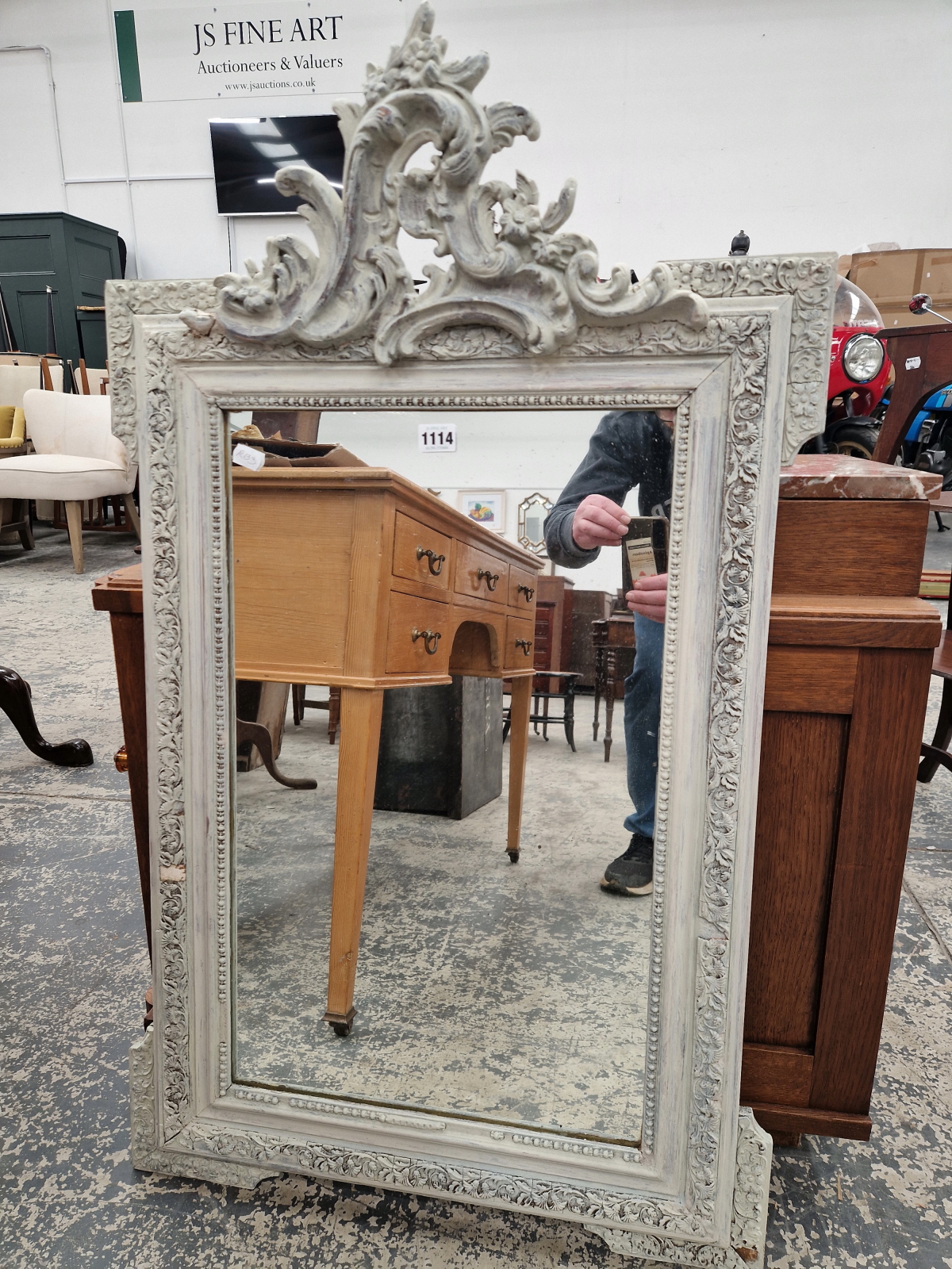 AN ANTIQUE WALL MIRROR WITH CARVED WOOD AND GESSO FRAME.