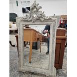 AN ANTIQUE WALL MIRROR WITH CARVED WOOD AND GESSO FRAME.