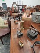 A PAIR OF SPIRALLY WROUGHT IRON FLOOR STANDING CANDLESTICKS, SIX CLOTHES IRONS, A MINERS LAMP AND