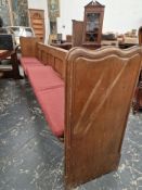 AN OAK PEW WITH PLANK ENDS AND WITH ANOTHER CENTRALLY. W 275cms.