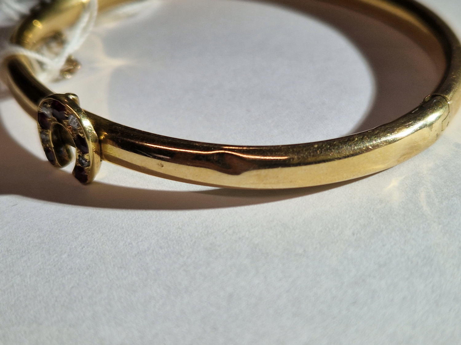 AN ANTIQUE BANGLE SET WITH A RUBY AND DIAMOND HORSESHOE. THE HINGED BANGLE UNHALLMARKED, ASSESSED AS - Image 5 of 8