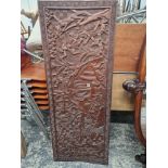 AN AFRICAN HARDWOOD PANEL CARVED IN RELIEF WITH A DEER HUNTING SCENE. 58 x 151cms.