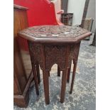 AN ISLAMIC MAHOGANY OCTAGONAL TABLE WITH A GEOMETRIC RELIEF CARVED TOP ABOVE EIGHT LEGS