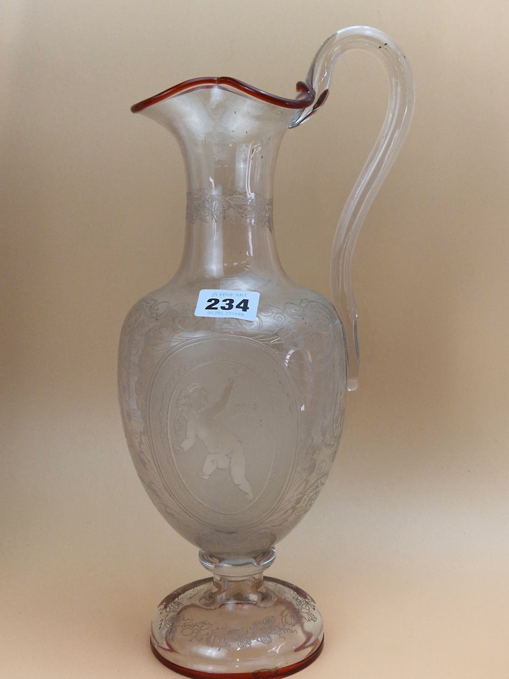 A CLEAR GLASS BALUSTER EWER ETCHED WITH CUPID OVALS AND WITH A CRANBERRY TRAILED RIM AND FOOT, A - Image 2 of 14