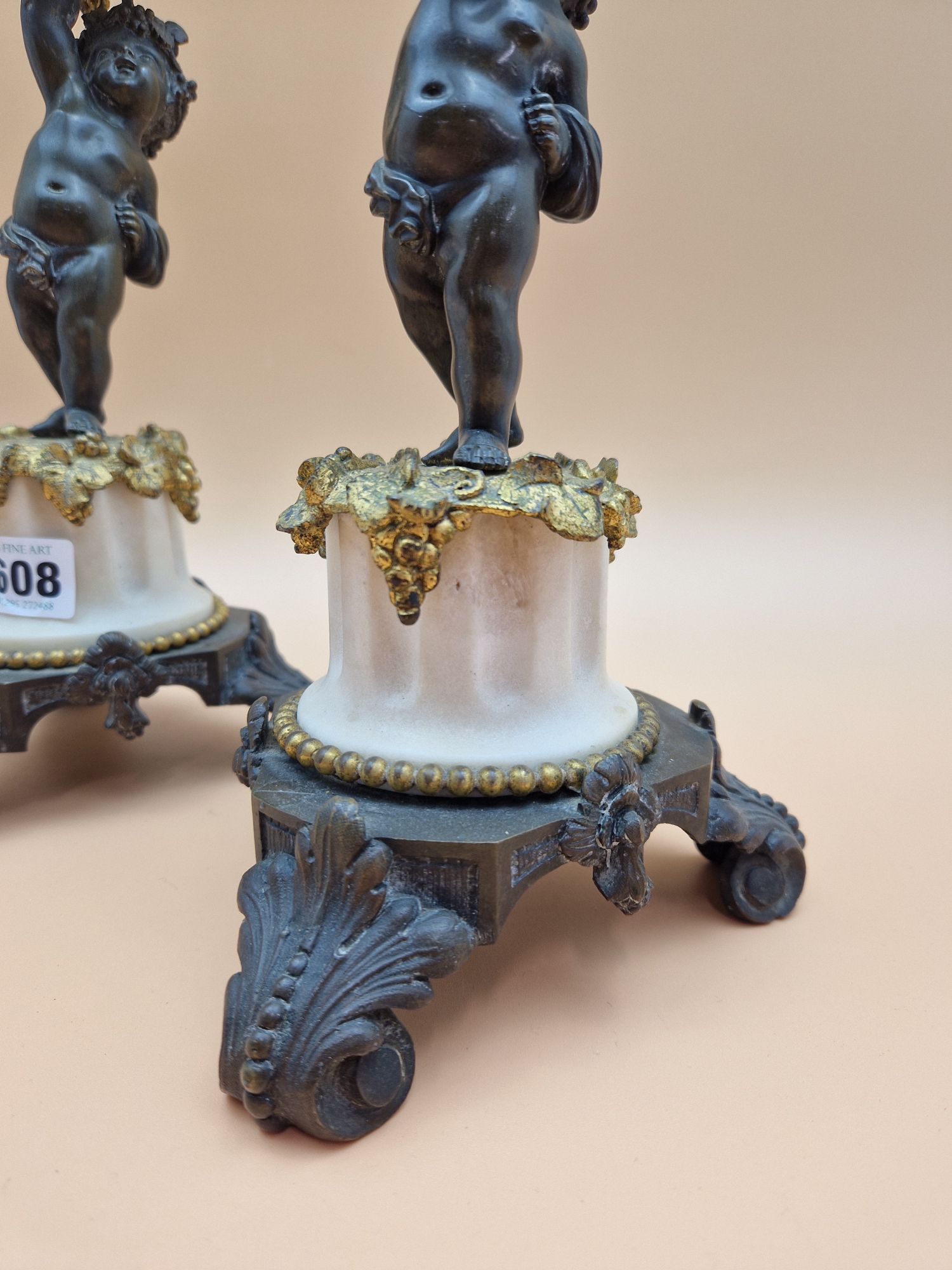 A PAIR OF LATE 19th C. BRONZE, ORMOLU AND WHITE MARBLE CANDLESTICKS HELD UP BY PUTTI STANDING ON - Image 4 of 5