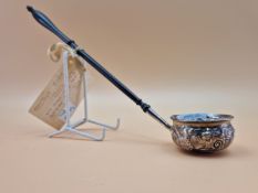 A TODDY LADLE INSET WITH A QUEEN ANNE COIN AND WITH AN EBONY HANDLE