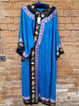 A CHINESE BLUE SILK ROBE EDGED IN PURPLE AND BLACK FLORAL EMBROIDERED BANDS