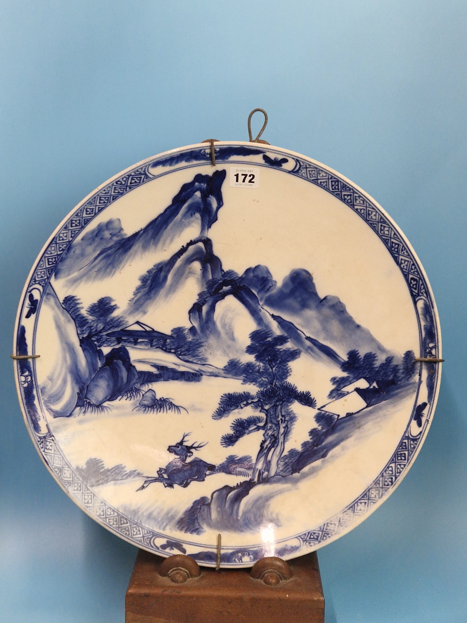 A PAIR OF CHINESE BLUE AND WHITE CHARGERS PAINTED WITH MOUNTAINOUS ISLANDS, A BUFFALO ON ONE AND A