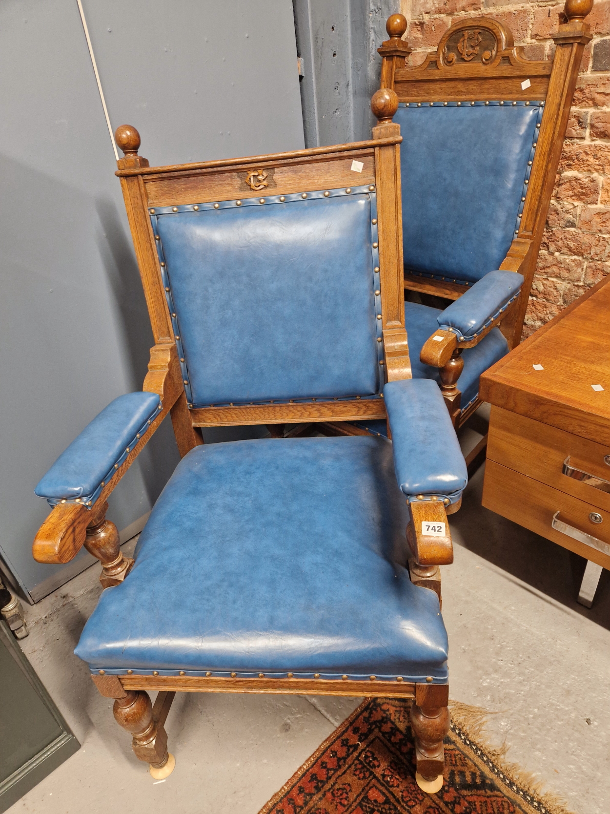 A PAIR OF EDWARDIAN OAK THRONE CHAIRS, EACH WITH THE CARVED MONOGRAMS C U BETWEEN THE BALL TOPPED