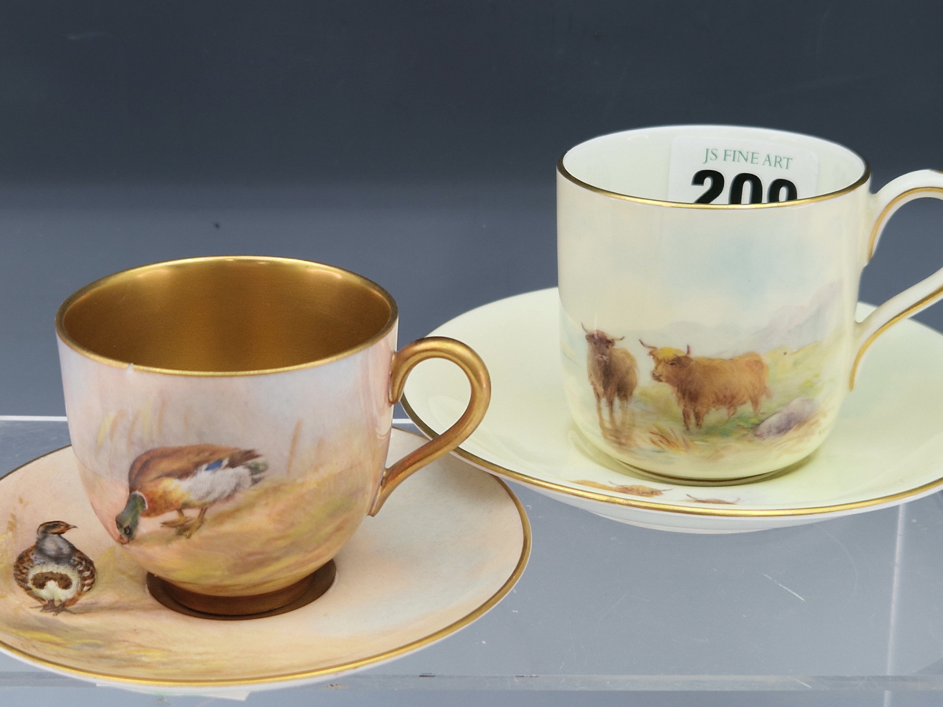 TWO ROYAL WORCESTER COFFEE CUPS AND SAUCERS, ONE PAINTED WITH CATTLE BY STINTON 1933 AND THE OTHER