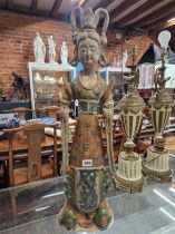 A TANG STYLE POTTERY FIGURE OF A LADY STANDING HOLDING PEGS IN EACH HAND, HER DRESS GLAZED IN OCHRE,