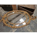 AN OVAL MIRROR WITHIN A FOLIATE GILT FRAME. 130 x 71cms.