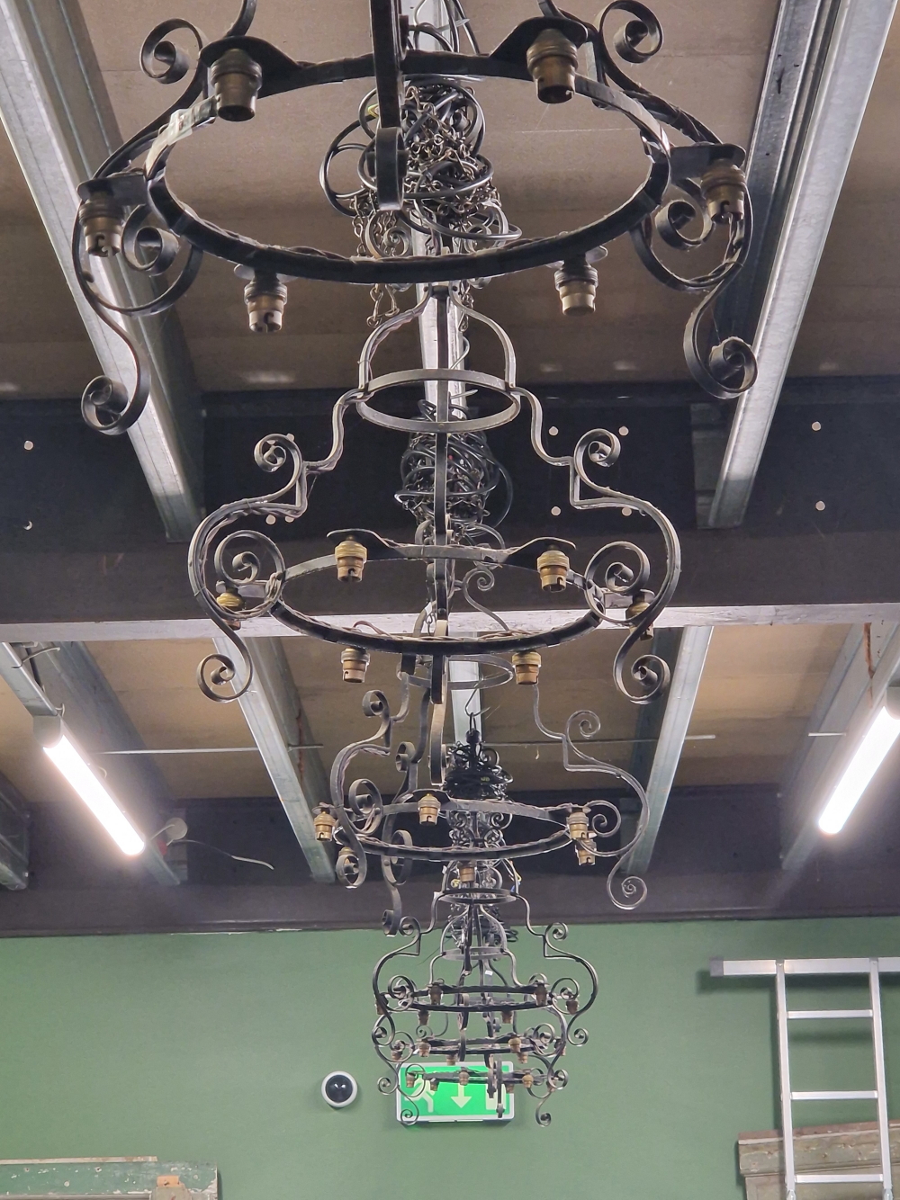 A SET OF SIX ECCLESIASTICAL WROUGHT IRON CHANDELIER LIGHT FITTINGS