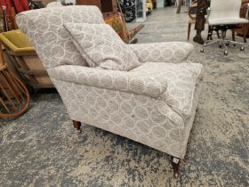 A HOWARD AND SONS ARMCHAIR UPHOLSTERED IN GREY CIRCLED MATERIAL, THE CASTER ON THE MAHOGANY BACK LEG