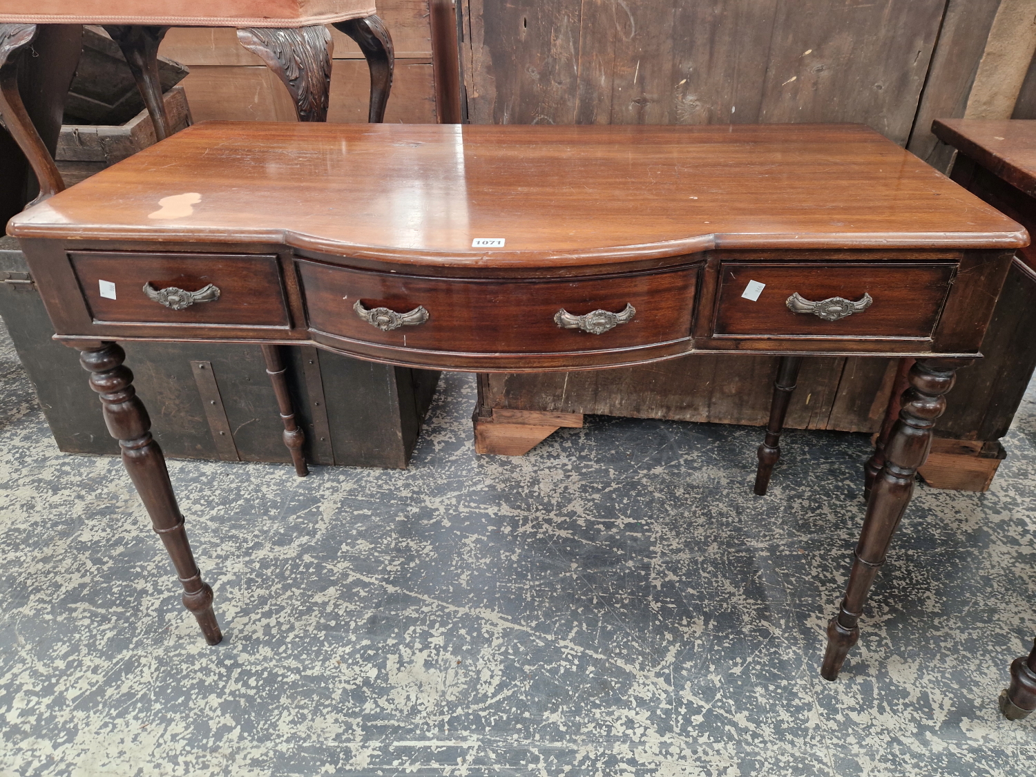 A MAHOGANY SIDE TABLE WITH THE CENTRAL BOW FRONTED DRAWER FLANKED BY TWO FLAT FRONTED DRAWERS, THE