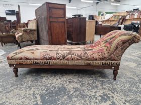 A VICTORIAN ARTS AND CRAFTS PERIOD OAK FRAMED DAY BED WITH KELIM UPHOLSTERY.