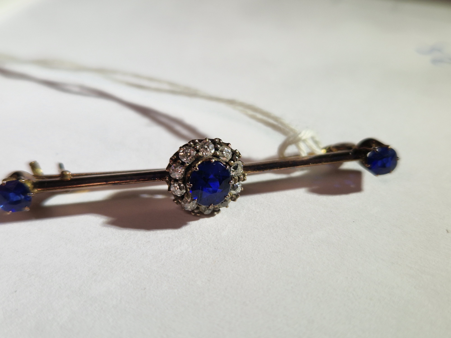 AN ANTIQUE SAPPHIRE AND DIAMOND BRA BROOCH. UNHALLMARKED, ASSESSED AS 9ct GOLD. LENGTH 4.6cms. - Image 5 of 7